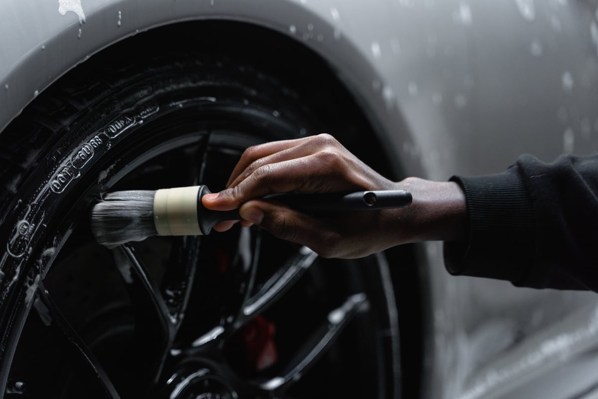 A Person Cleaning Tire of a Car